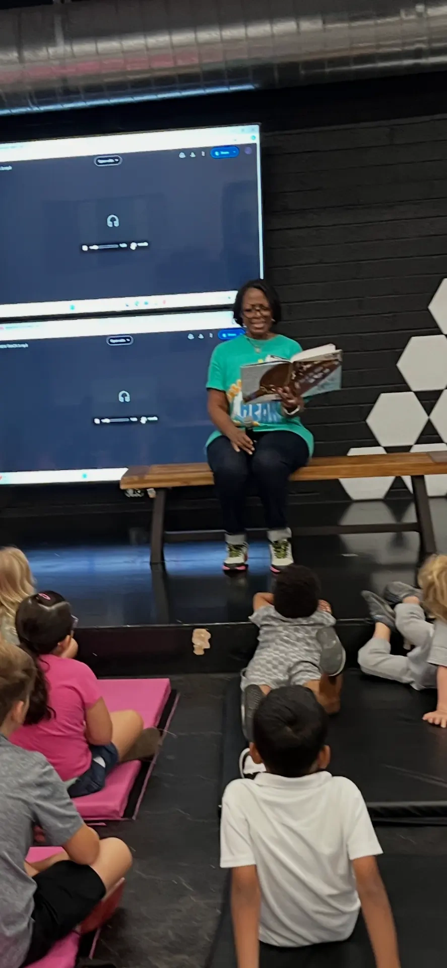 Kimberly T. Smith seated and reading to a group of children